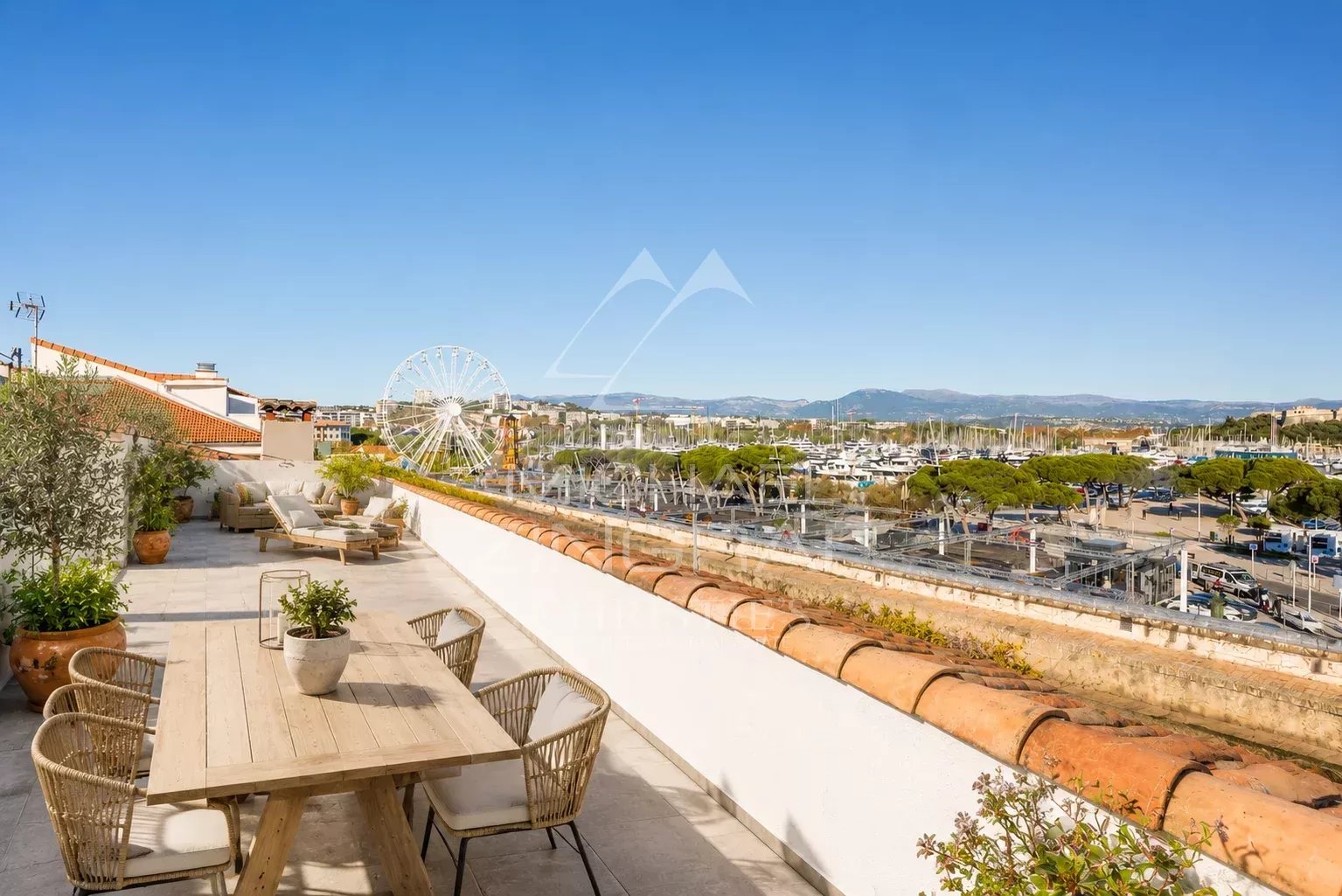 Terrasse d'un appartement avec vue panoramique sur le port d'Antibes et la ville.