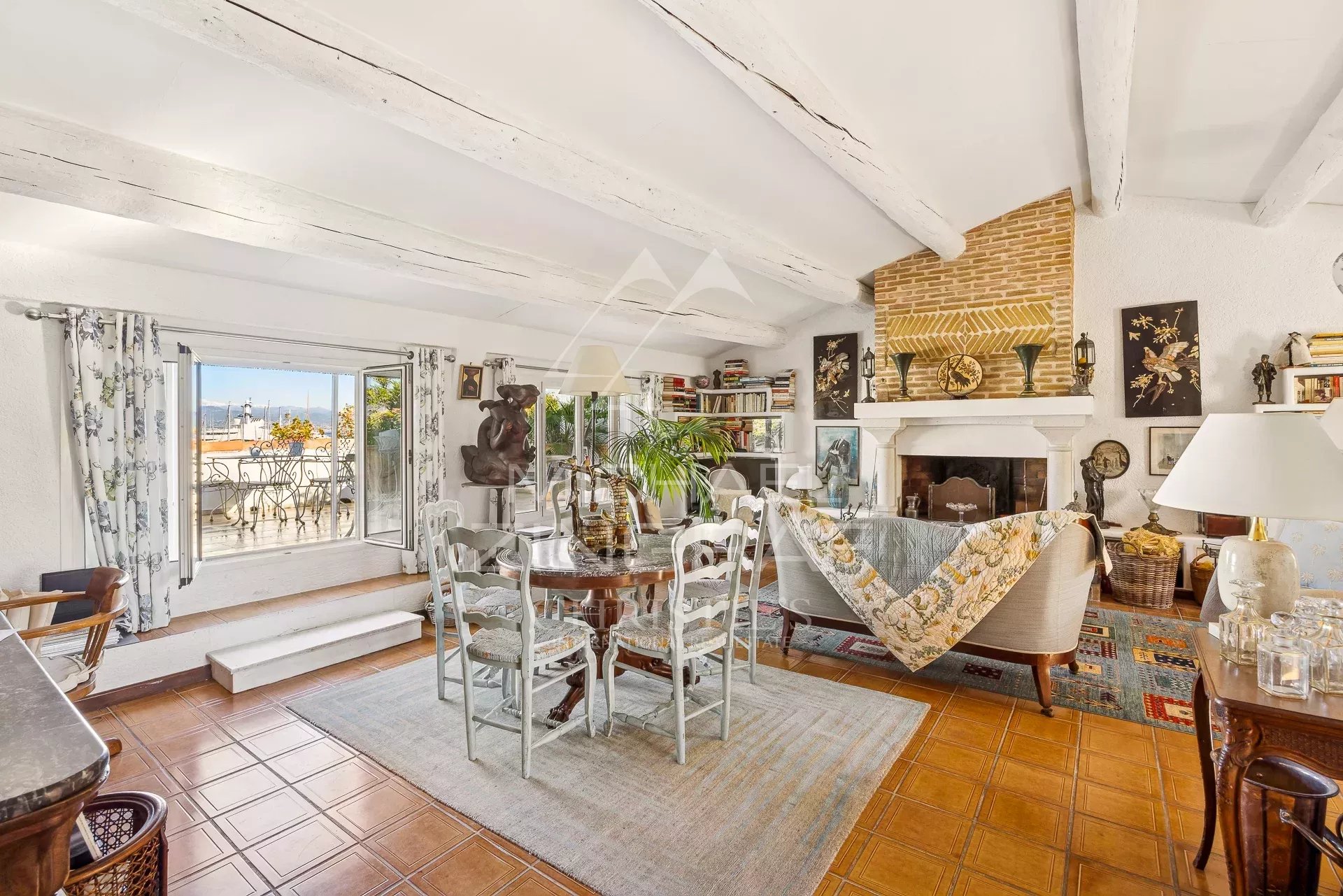Intérieur d'un appartement spacieux avec salon, salle à manger et cheminée, décoré avec goût.
