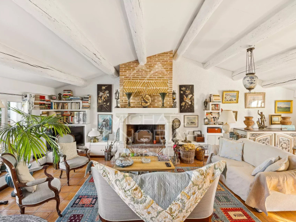 Salon spacieux d'un appartement avec cheminée, meubles élégants et décoration artistique.