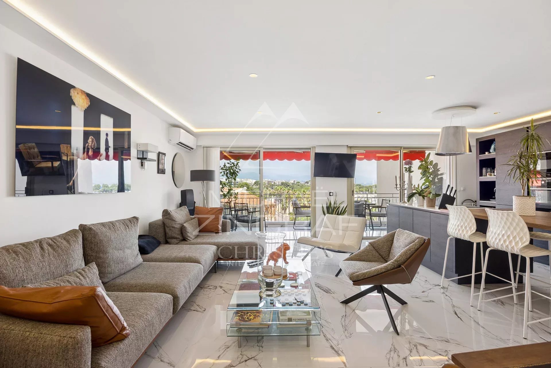 Appartement rénové avec salon moderne et vue sur le port d'Antibes.
