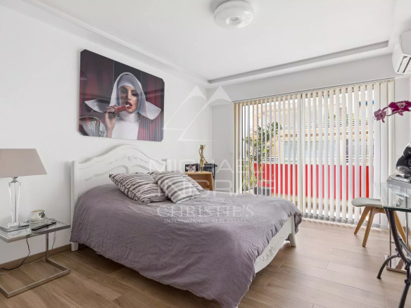 Chambre d'un appartement rénové avec lit et décoration moderne à Antibes.