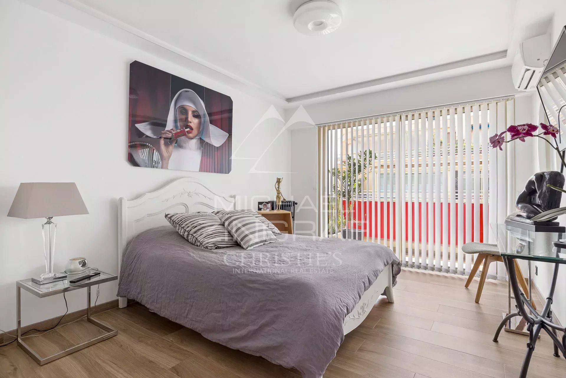 Chambre d'un appartement rénové avec lit et décoration moderne à Antibes.