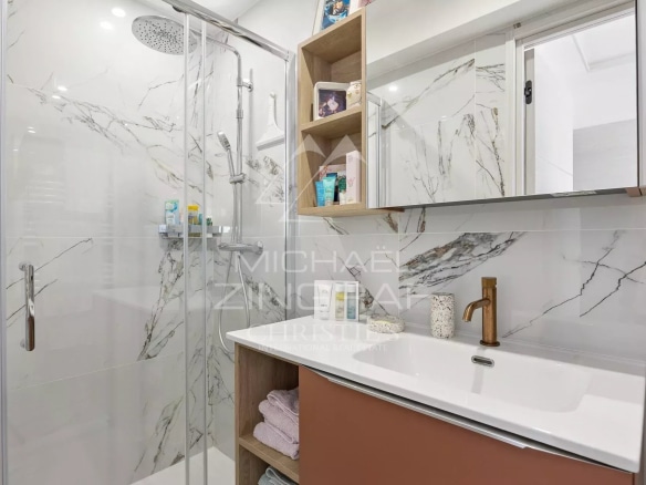 Salle de bain moderne avec douche en verre et meuble vasque, appartement rénové à Antibes.