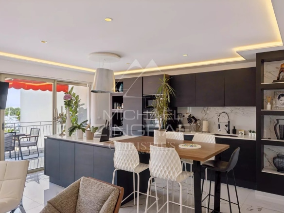 Cuisine moderne ouverte sur un séjour lumineux dans un appartement rénové à Antibes.