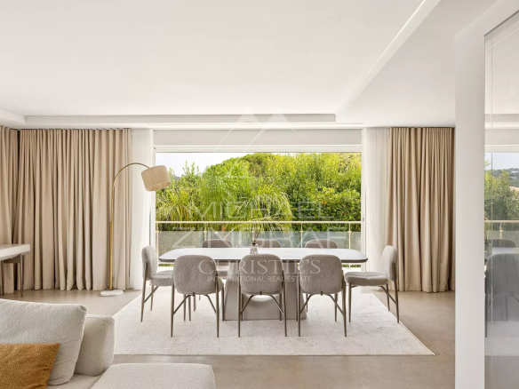 Interior of a contemporary villa with a bright dining room and views of nature.