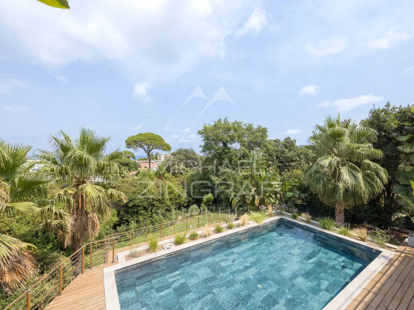 View of the pool surrounded by palm trees in a contemporary villa in Antibes.