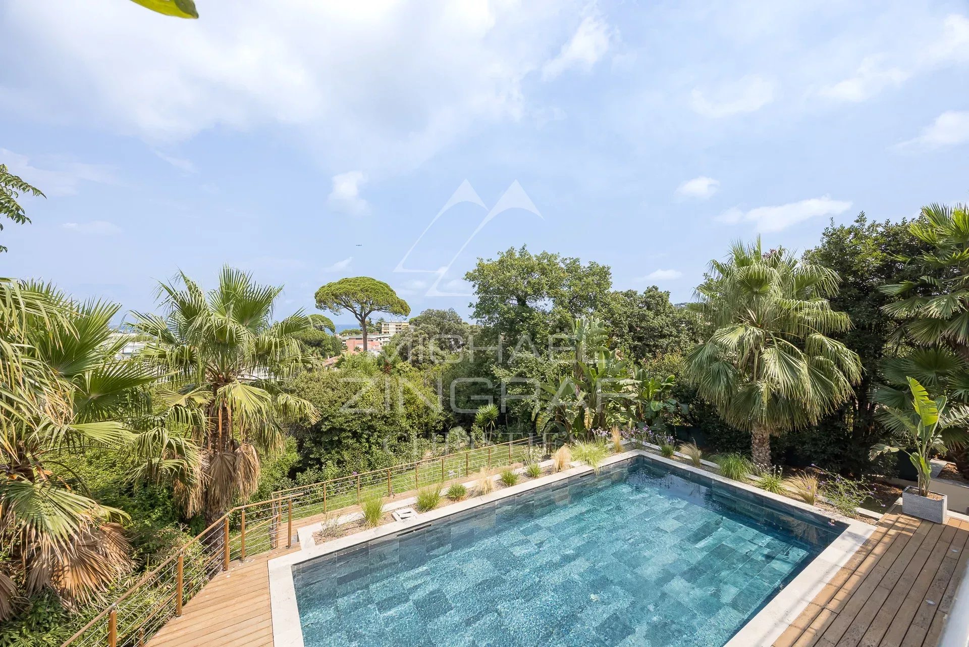View of the pool surrounded by palm trees in a contemporary villa in Antibes.