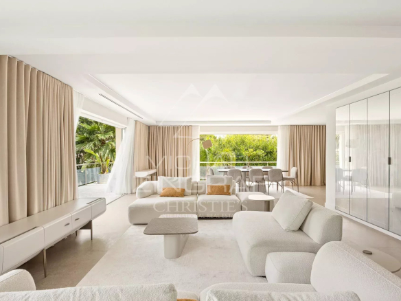Interior of a renovated contemporary villa with a bright living room and large windows.