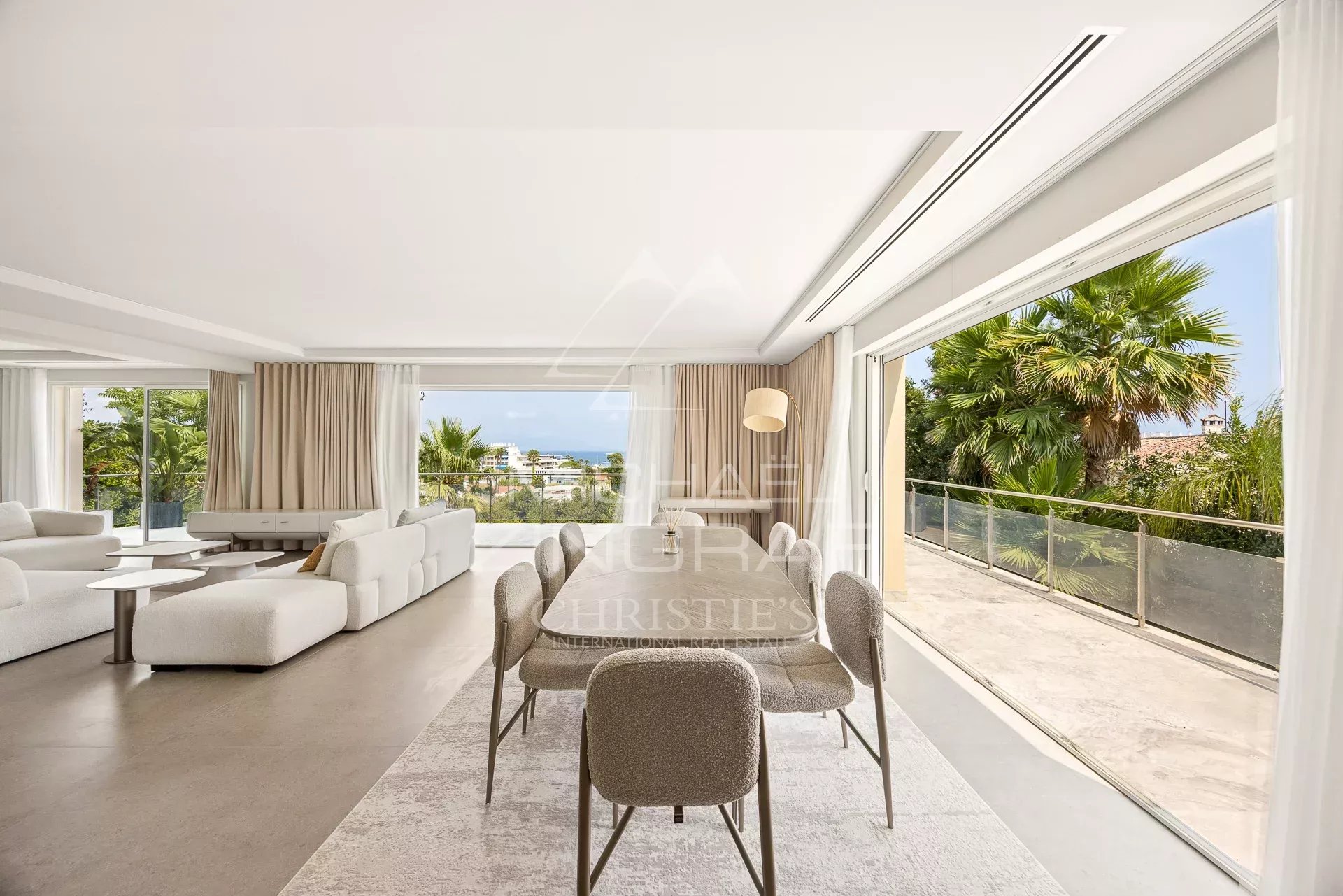 Interior of a renovated contemporary villa with living room and dining room, garden view.