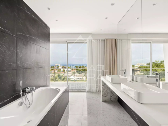 Modern bathroom with bathtub and double sink, view of the outside.