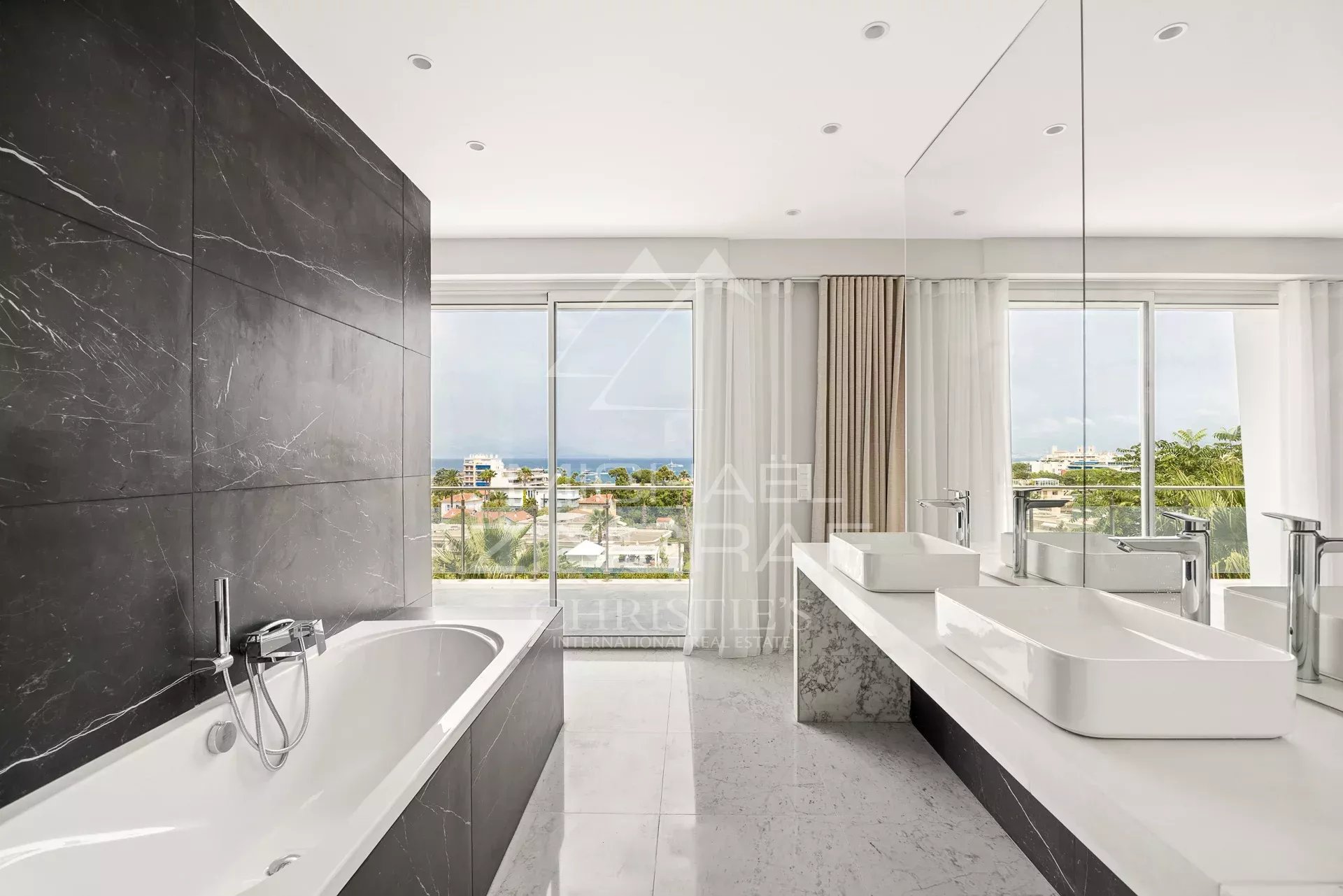 Modern bathroom with bathtub and double sink, view of the outside.