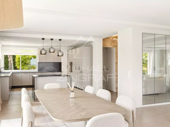 Interior of a renovated contemporary villa with dining room and open kitchen.