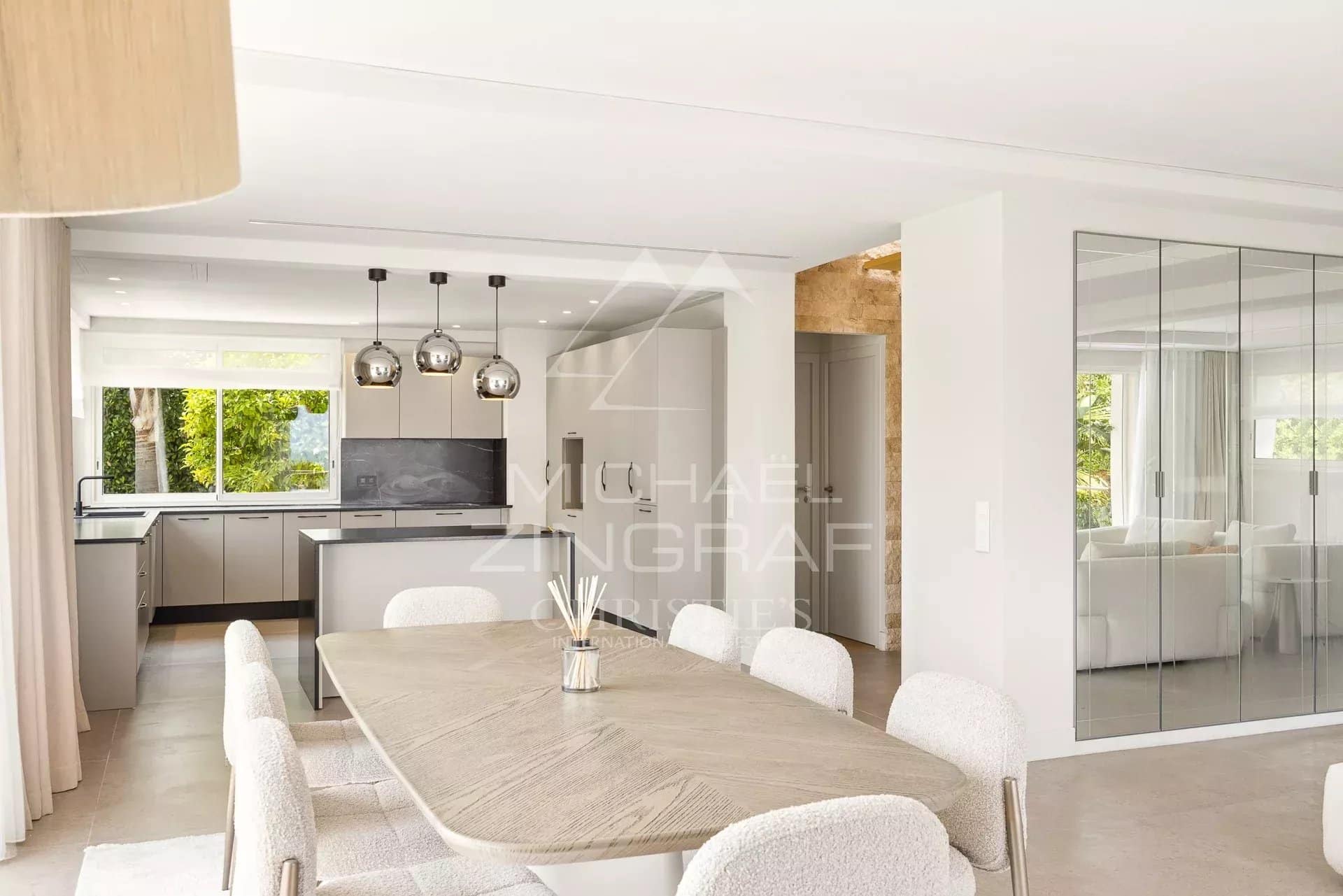 Interior of a renovated contemporary villa with dining room and open kitchen.