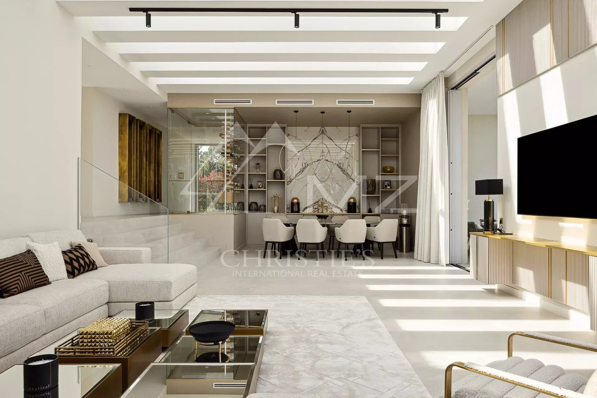 Intérieur moderne d'une villa de luxe à Antibes avec salon lumineux et espace de vie ouvert.
