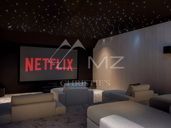 Cinema room with projection screen and comfortable sofas.