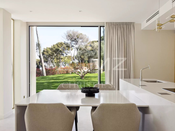 Modern interior of a villa overlooking a garden and trees.