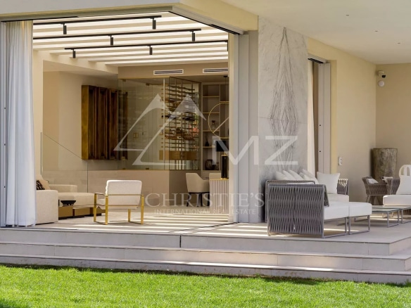 Intérieur moderne d'une villa de luxe avec salon spacieux et terrasse, vue sur la mer.