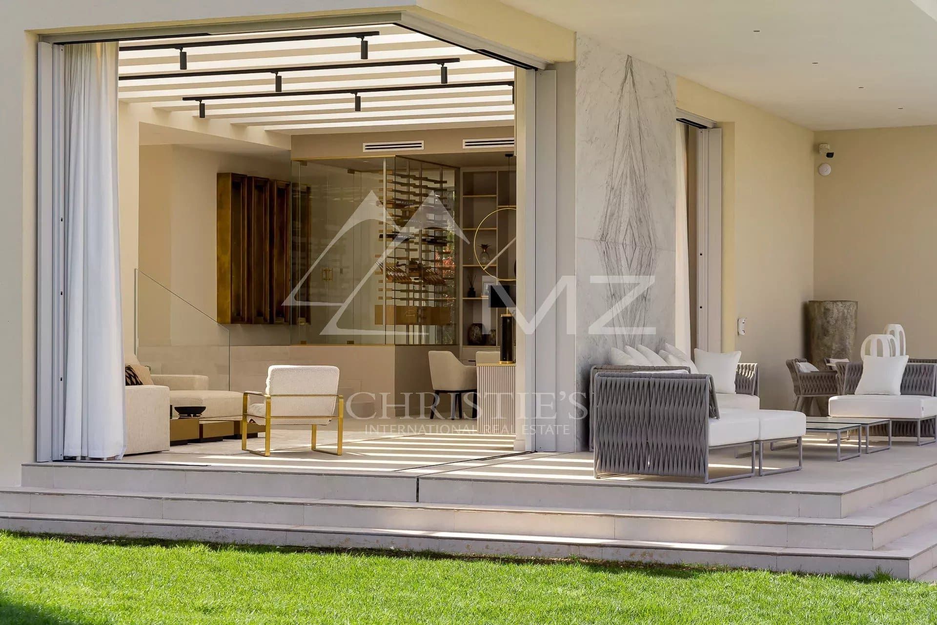 Intérieur moderne d'une villa de luxe avec salon spacieux et terrasse, vue sur la mer.