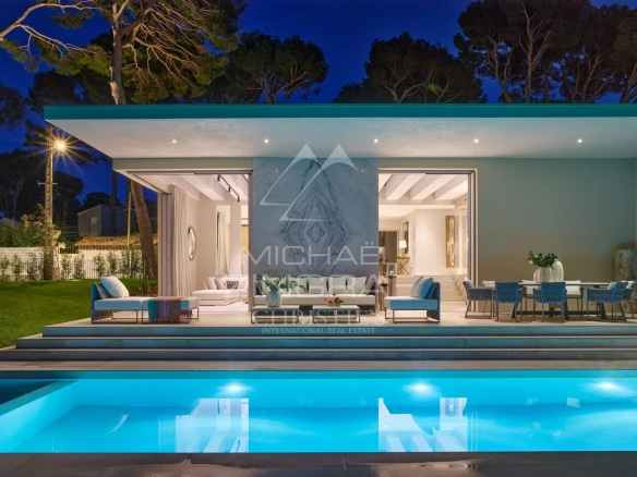 Villa moderne avec piscine et terrasse, éclairée la nuit, à Cap d'Antibes.