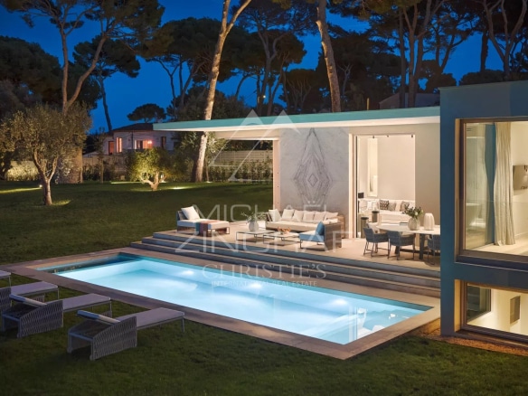 Villa moderne avec piscine et jardin à Antibes, vue sur la mer au crépuscule.