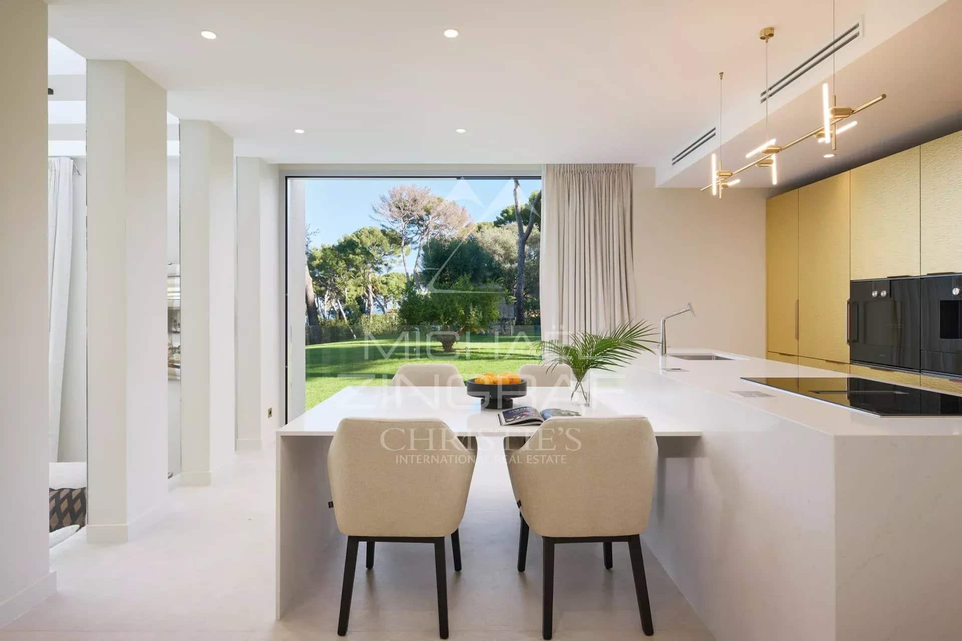 Intérieur moderne d'une villa de luxe avec cuisine ouverte et vue sur le jardin.