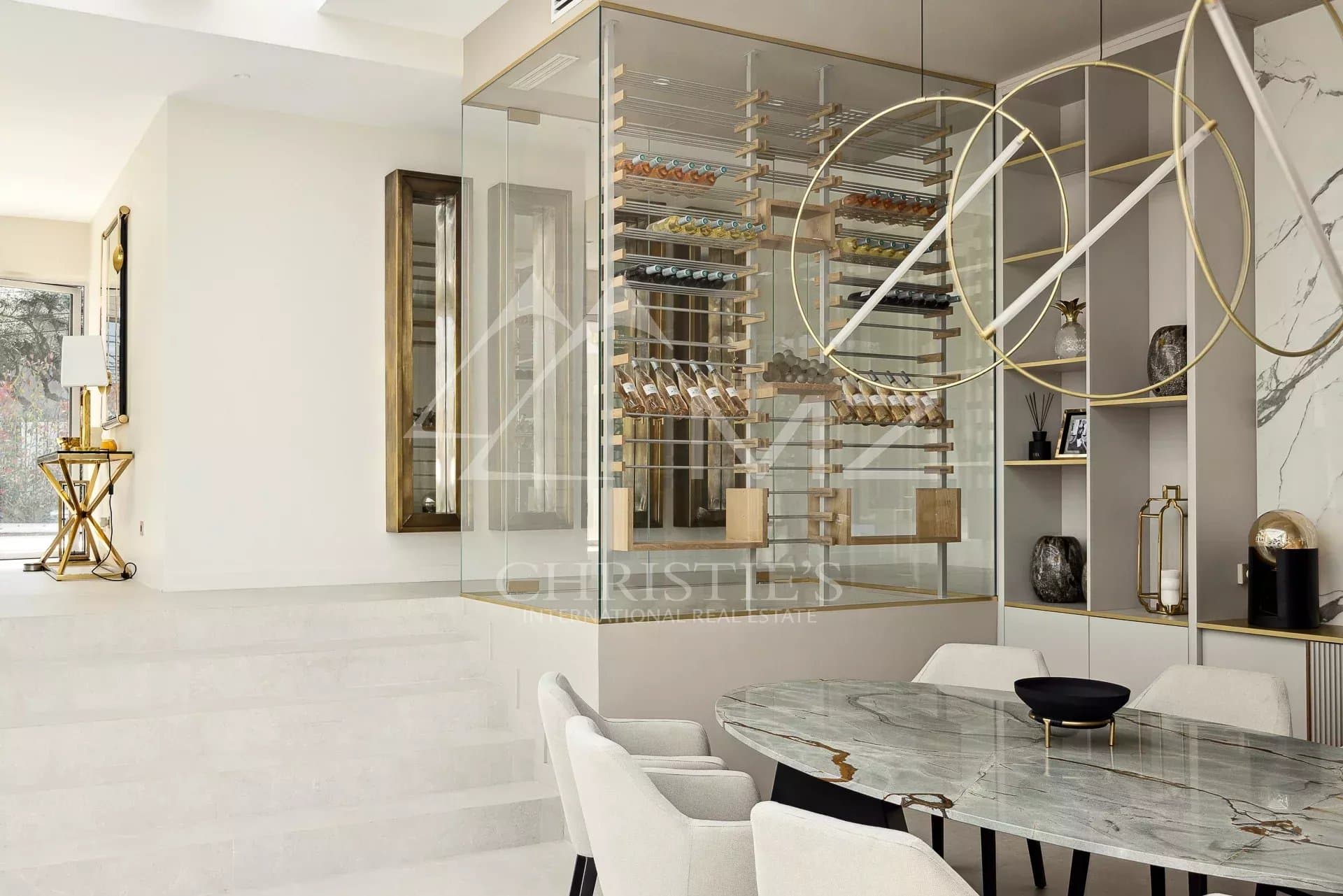 Intérieur d'une villa moderne avec une salle à manger élégante et un espace de rangement à vin.