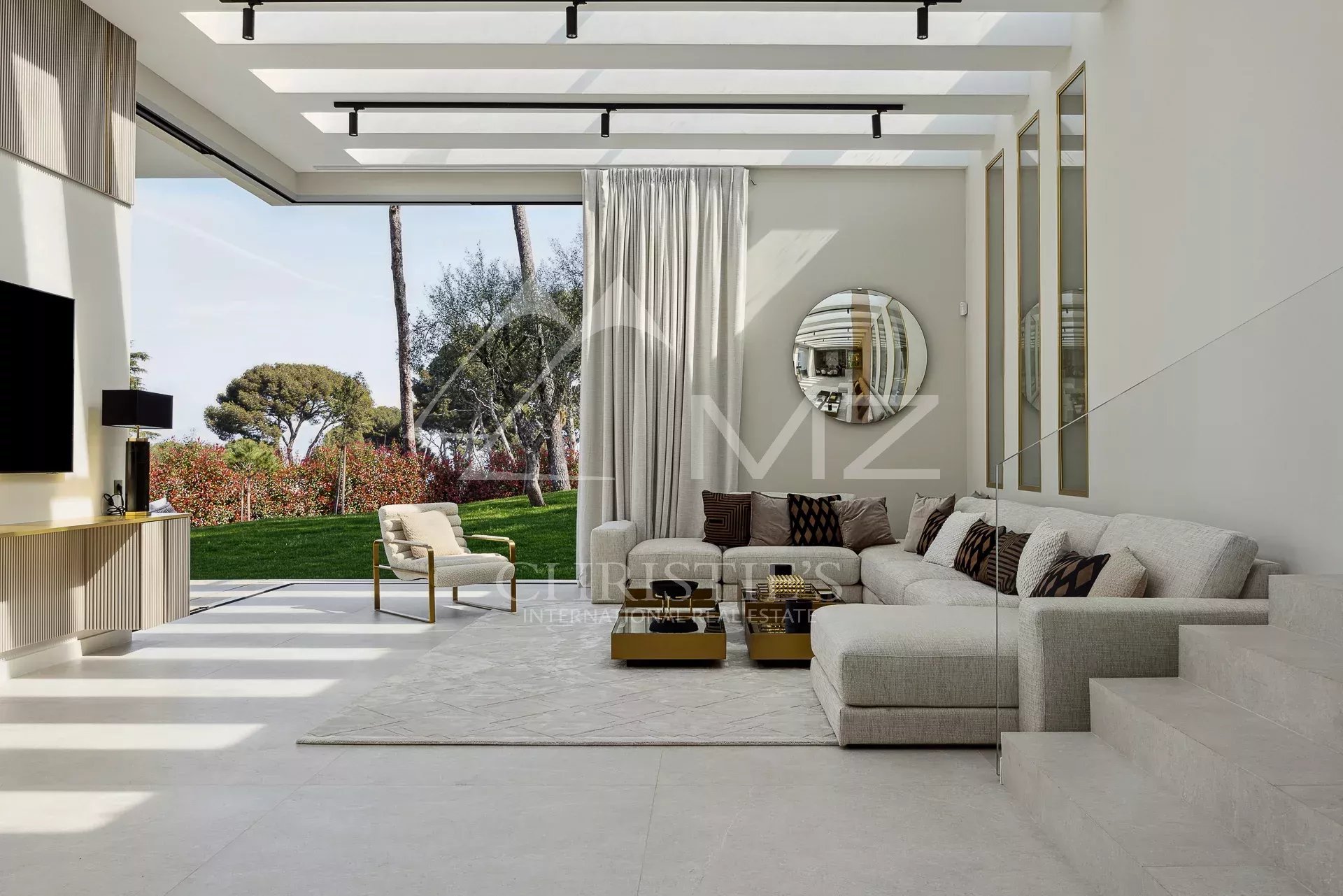 Intérieur d'une villa moderne avec salon lumineux et vue sur le jardin à Antibes.