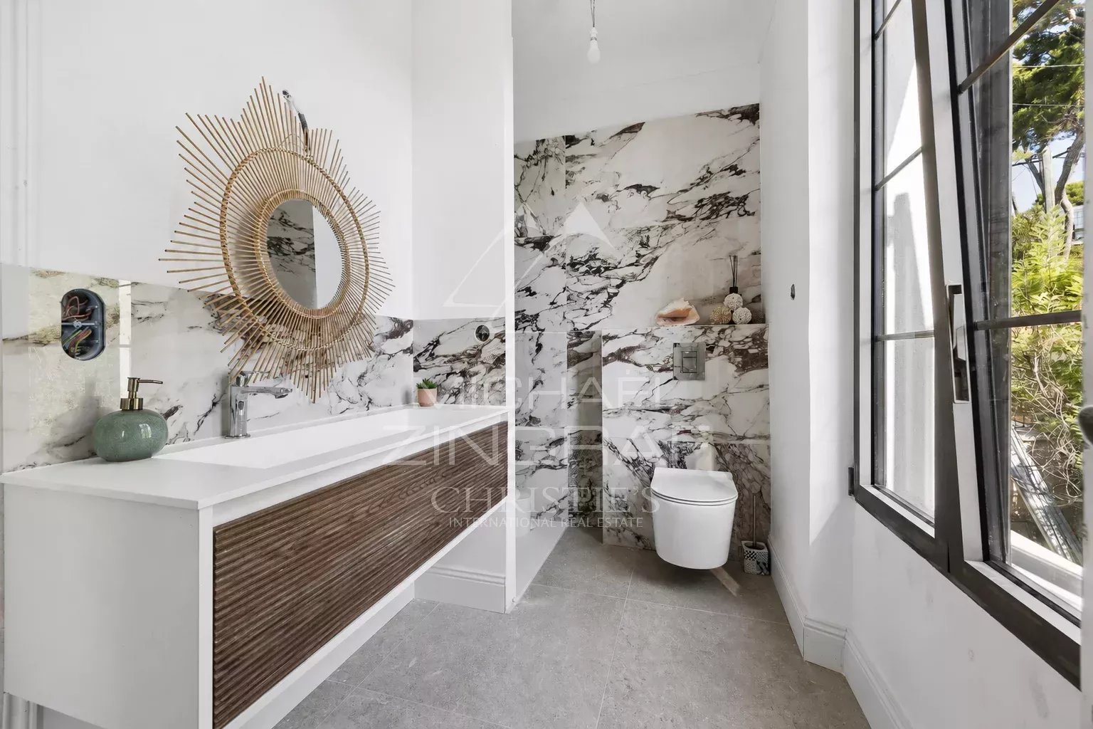 Salle de bain contemporaine Salle de bain moderne avec miroir rond et décor en marbre.