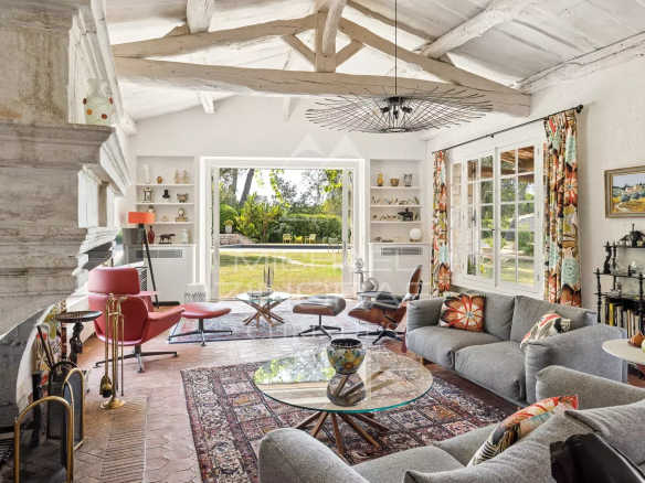 Interior of a Provençal farmhouse with bright living room, fireplace and modern furniture in Cap d'Antibes.