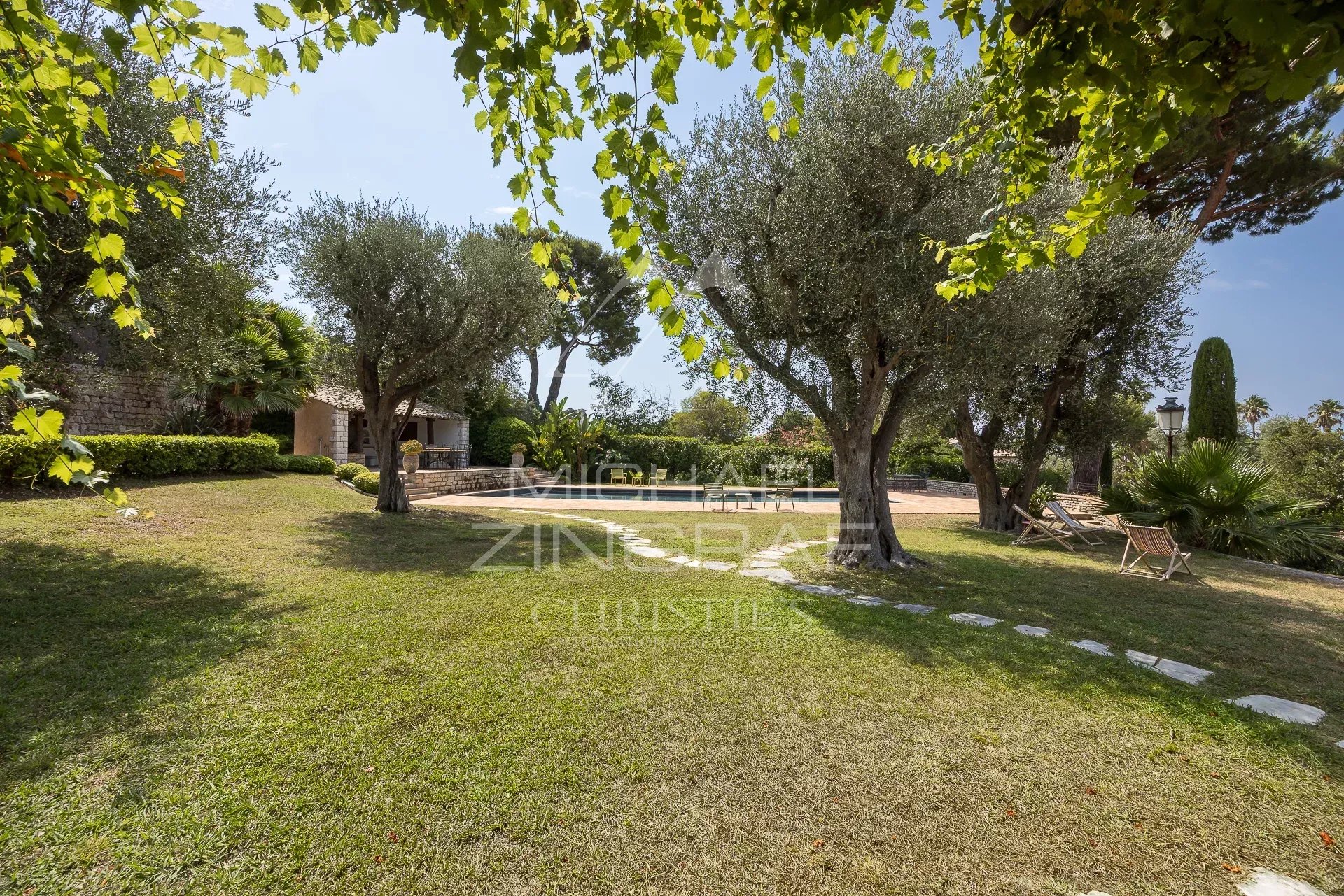 Garden at Cap d'Antibes Green garden with olive trees and relaxation area at Cap d'Antibes.