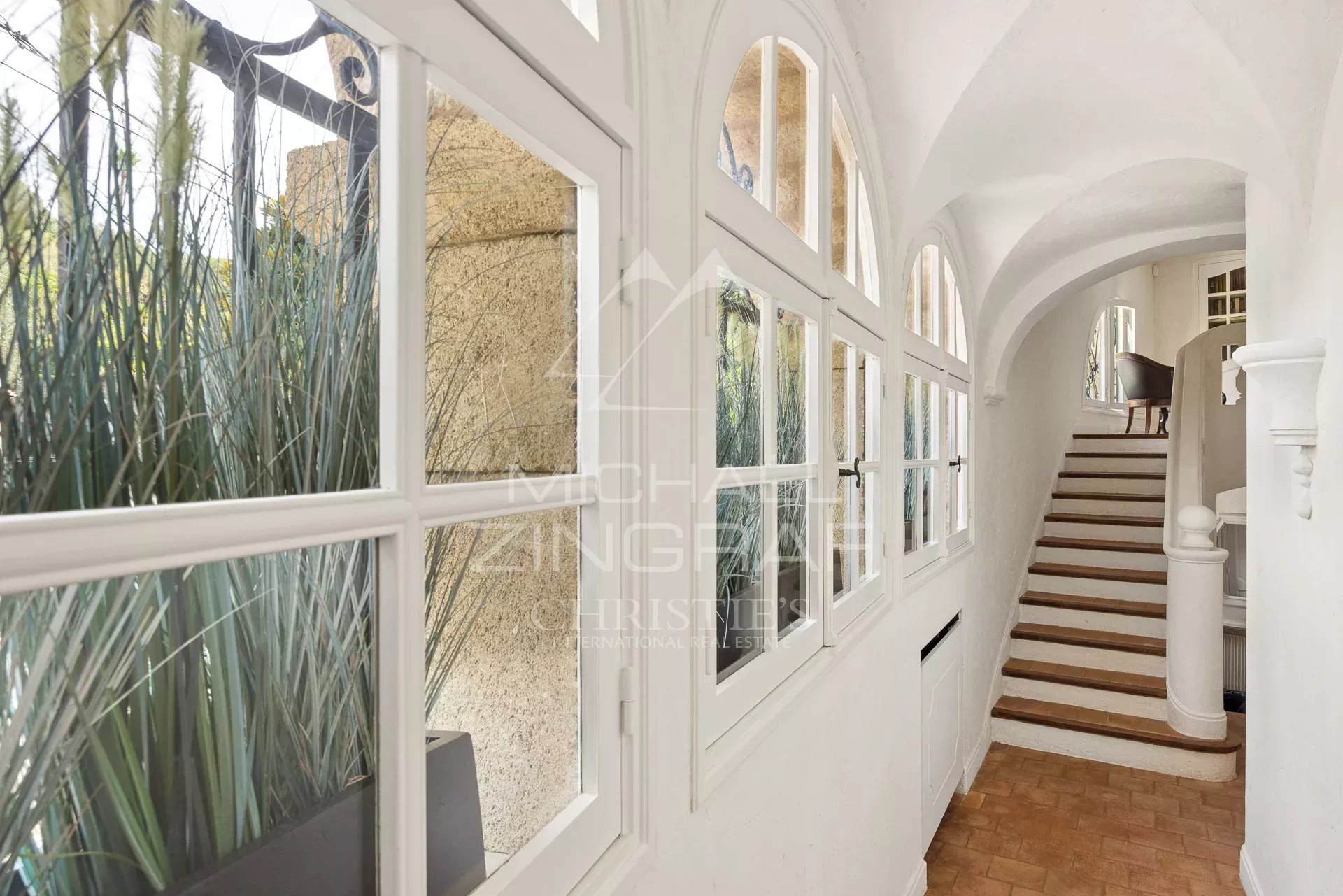 Interior of a Provençal farmhouse in Antibes Interior of a Provençal farmhouse with arched windows and a wooden staircase in Antibes.