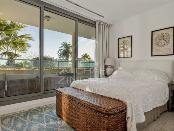 Chambre d'un appartement moderne avec vue sur des palmiers au Cap d'Antibes.