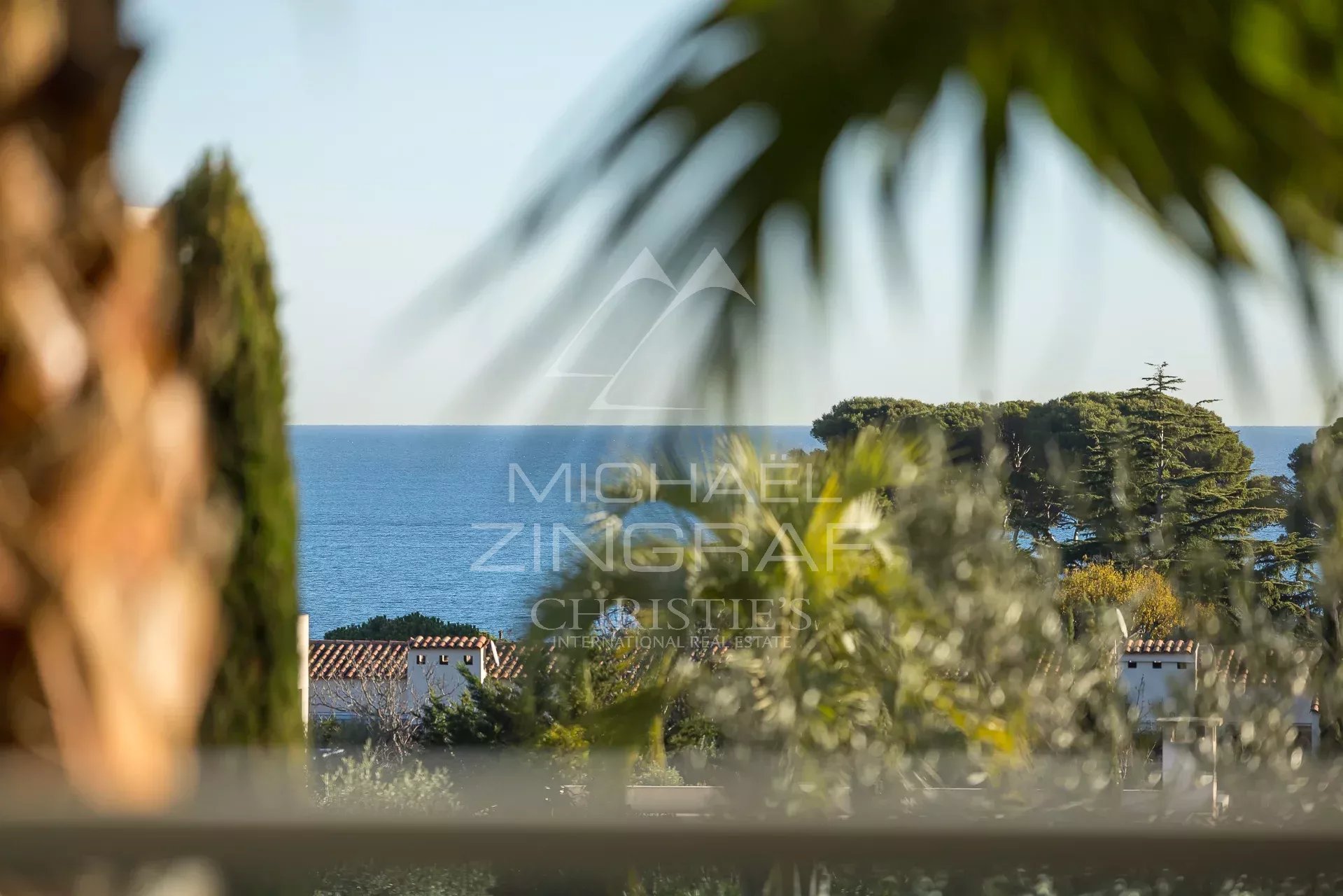 Vue depuis un appartement au Cap d’Antibes Vue sur la mer depuis un appartement au Cap d'Antibes, avec des palmiers en avant-plan.