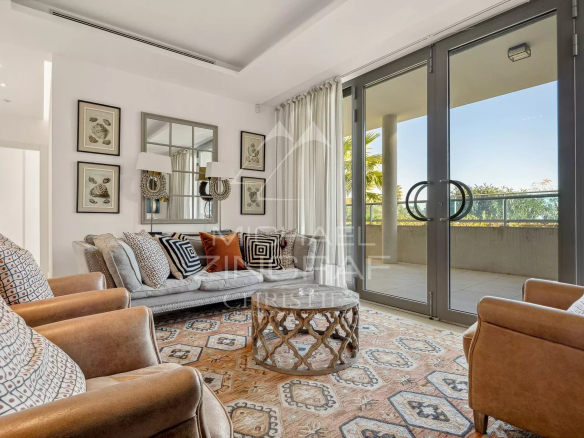 Salon d'un appartement moderne avec canapés et accès à un balcon au Cap d'Antibes.