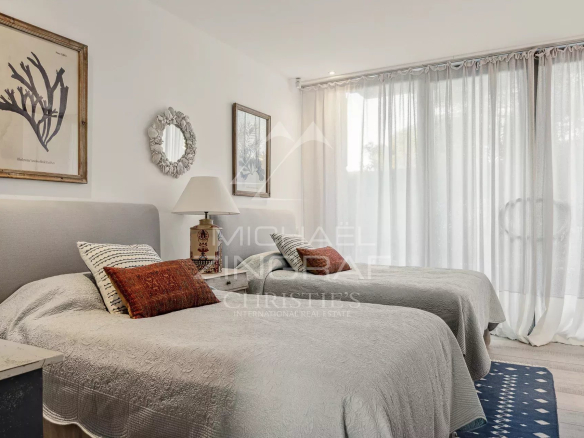Chambre d'un appartement moderne avec deux lits simples et décoration élégante.