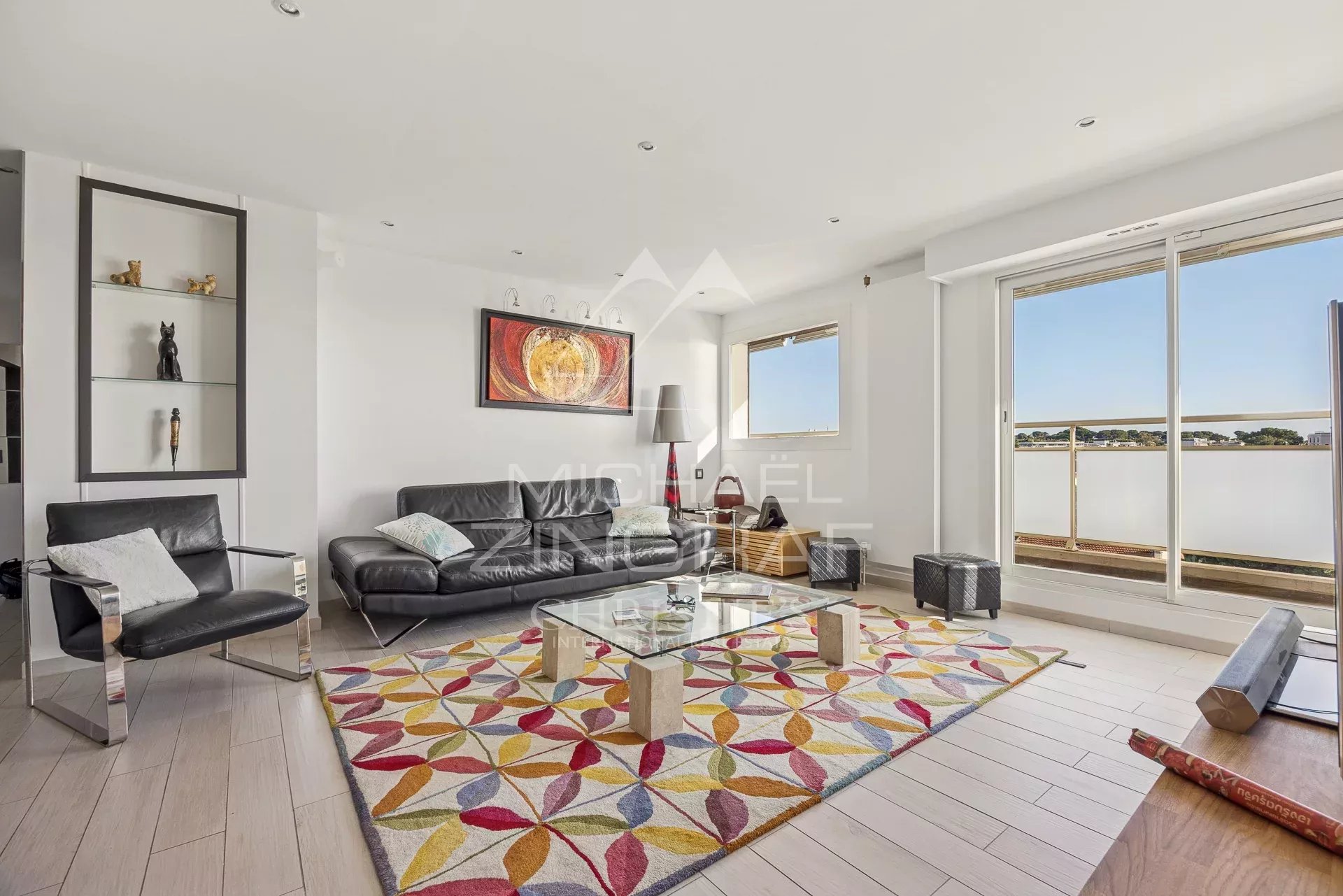 Intérieur d'un appartement moderne avec salon lumineux et vue sur la mer.