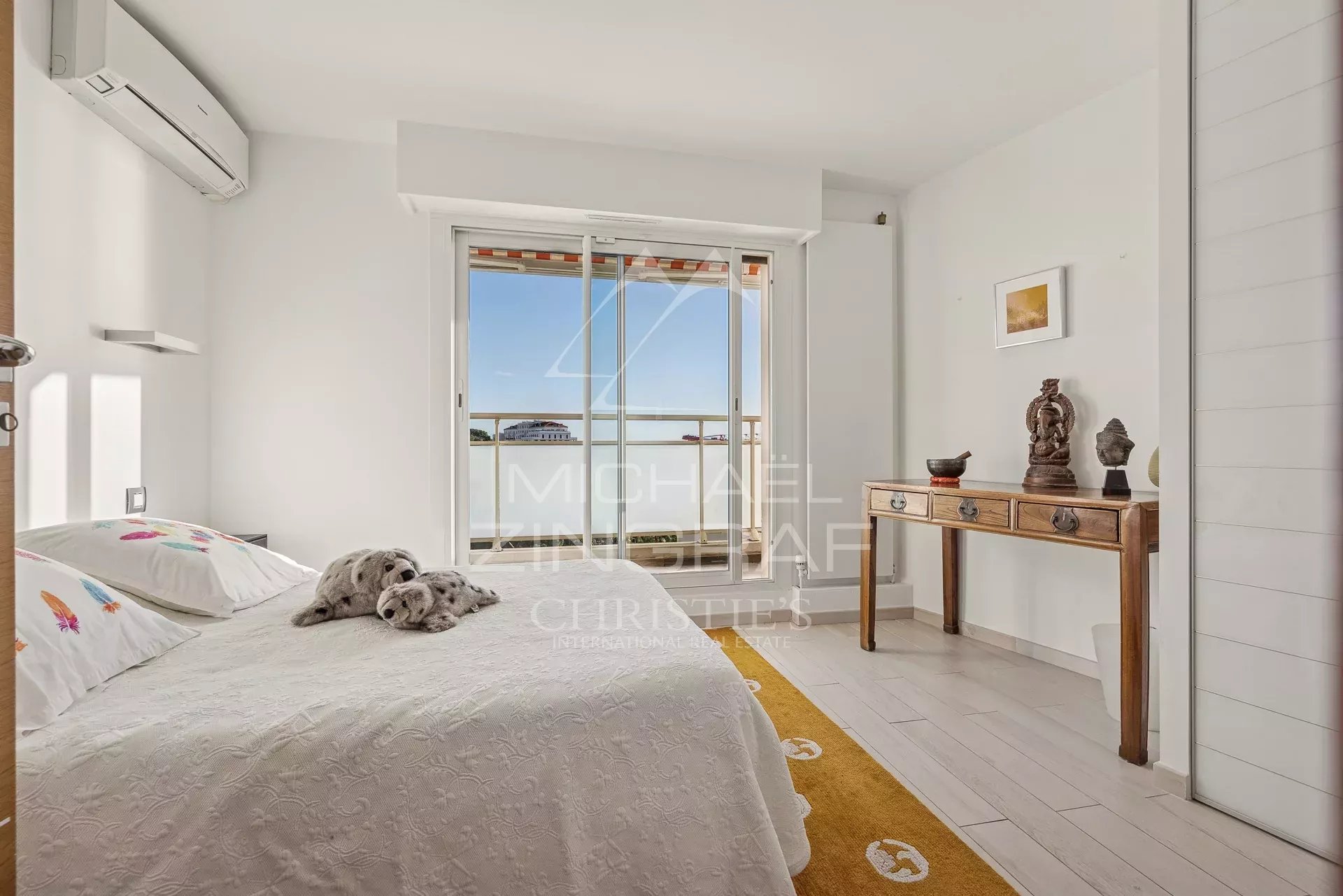 Chambre lumineuse avec lit, accès à un balcon, décor moderne et accueillant.