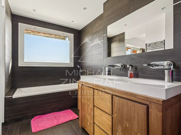 Salle de bain moderne avec baignoire et double vasque, lumière naturelle
