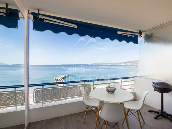 Terrasse avec vue sur la mer Méditerranée à Juan-les-Pins, table et chaises blanches.