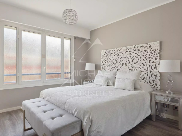Chambre d'un appartement avec lit double et décoration élégante à Juan-les-Pins.