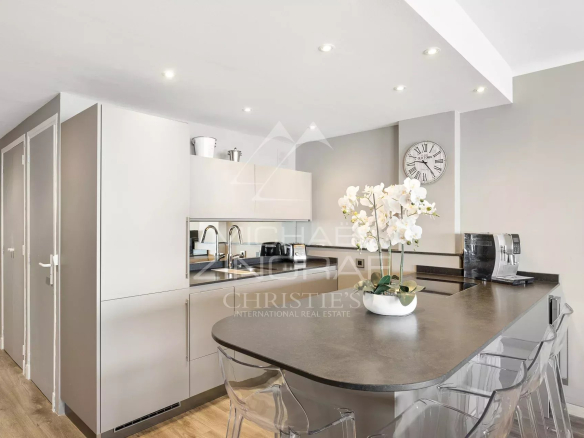 Intérieur d'un appartement moderne avec cuisine américaine et bar, lumineux et élégant.