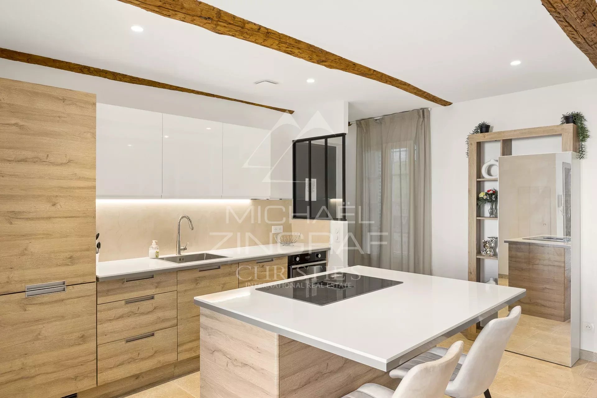 Cuisine d’un duplex à Antibes Cuisine moderne d'un duplex à Antibes avec un îlot central et des meubles en bois clair.