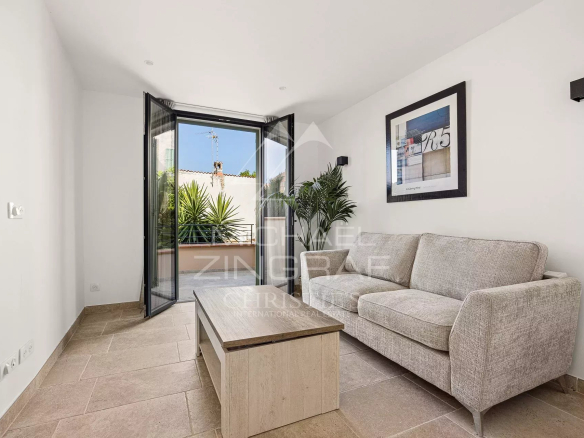 Salon lumineux d'un duplex avec canapé et accès à une terrasse à Antibes.