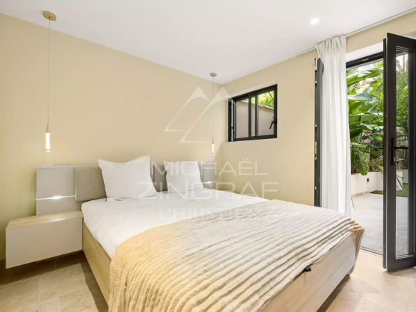 Chambre d'un duplex à Antibes avec lit et accès à un jardin.