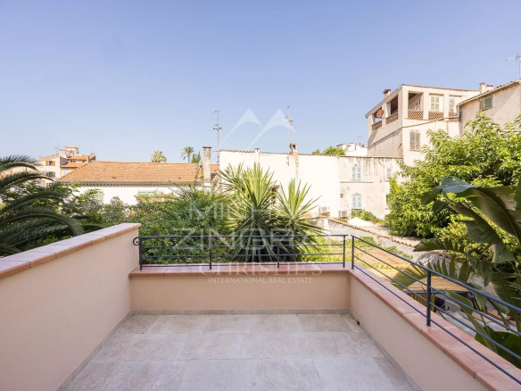 Terrasse d'un duplex à Antibes avec vue sur des jardins et des bâtiments historiques.