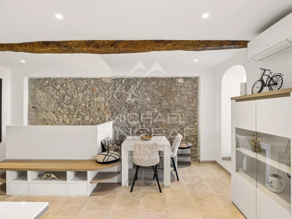 Intérieur d'un duplex à Antibes avec murs en pierre et mobilier moderne.