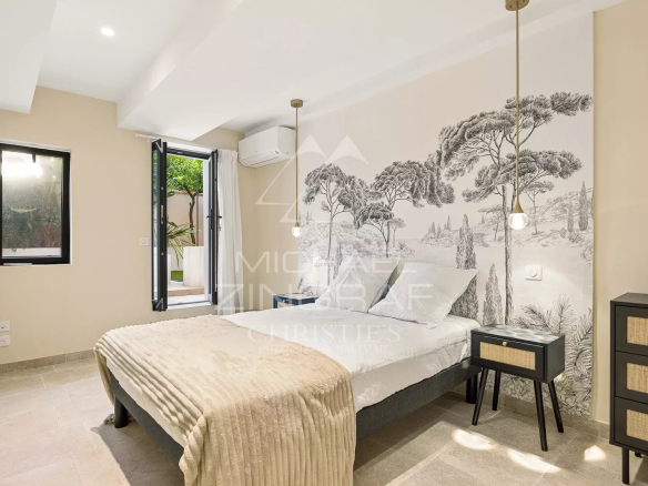Chambre d'un duplex à Antibes avec lit, décoration moderne et accès à l'extérieur.