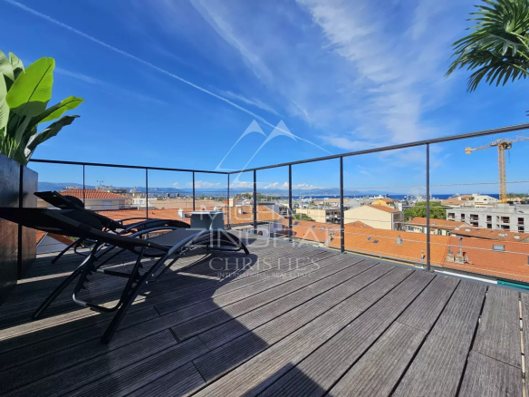Terrasse d'un loft d'architecte à Antibes avec chaises longues et vue panoramique.