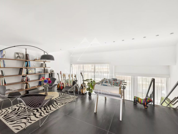 Intérieur d'un loft d'architecte à Antibes avec salon, bibliothèque et espace de loisirs.