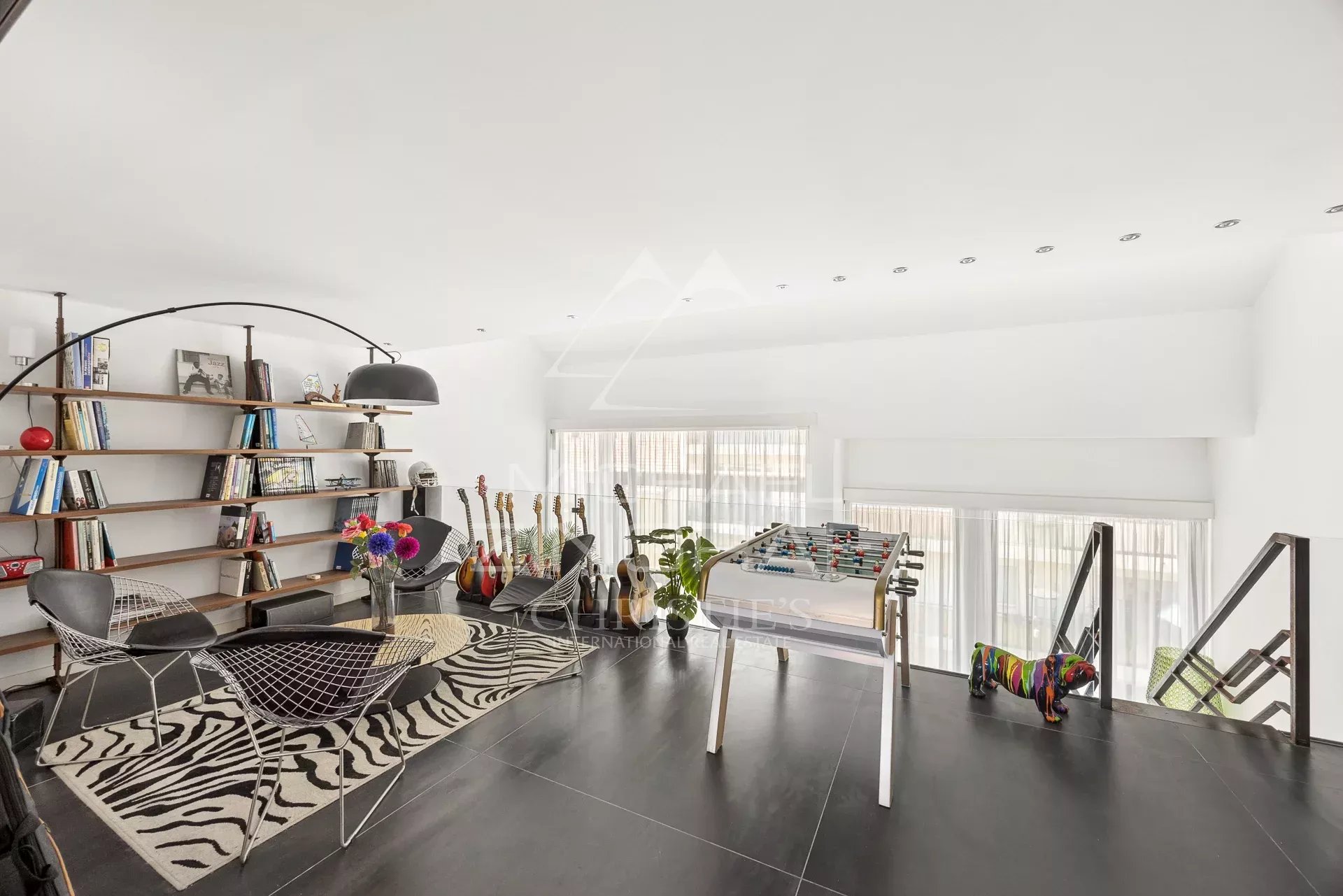 Intérieur d'un loft d'architecte à Antibes avec salon, bibliothèque et espace de loisirs.